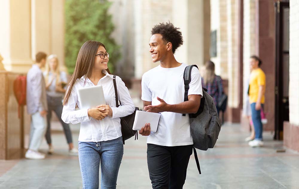 young college students walking while talking on campus