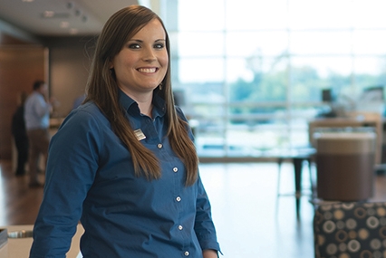 DCCU employee, Miranda, smiling inside a branch