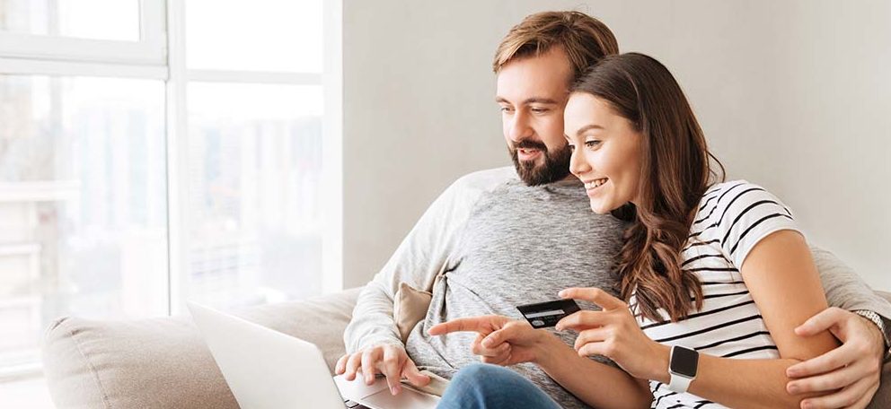 couple making a purchase together on a laptop with credit cards