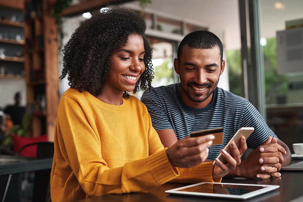 couple making a purchase together on a mobile device using a credit card