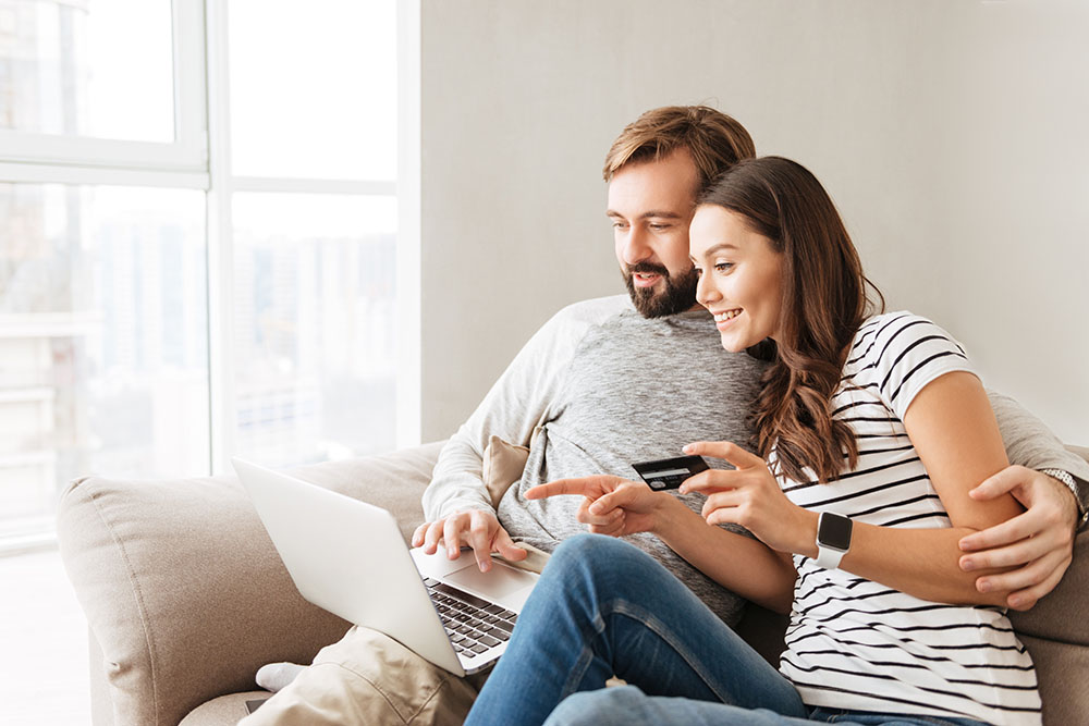 couple making a purchase together on a laptop with credit cards