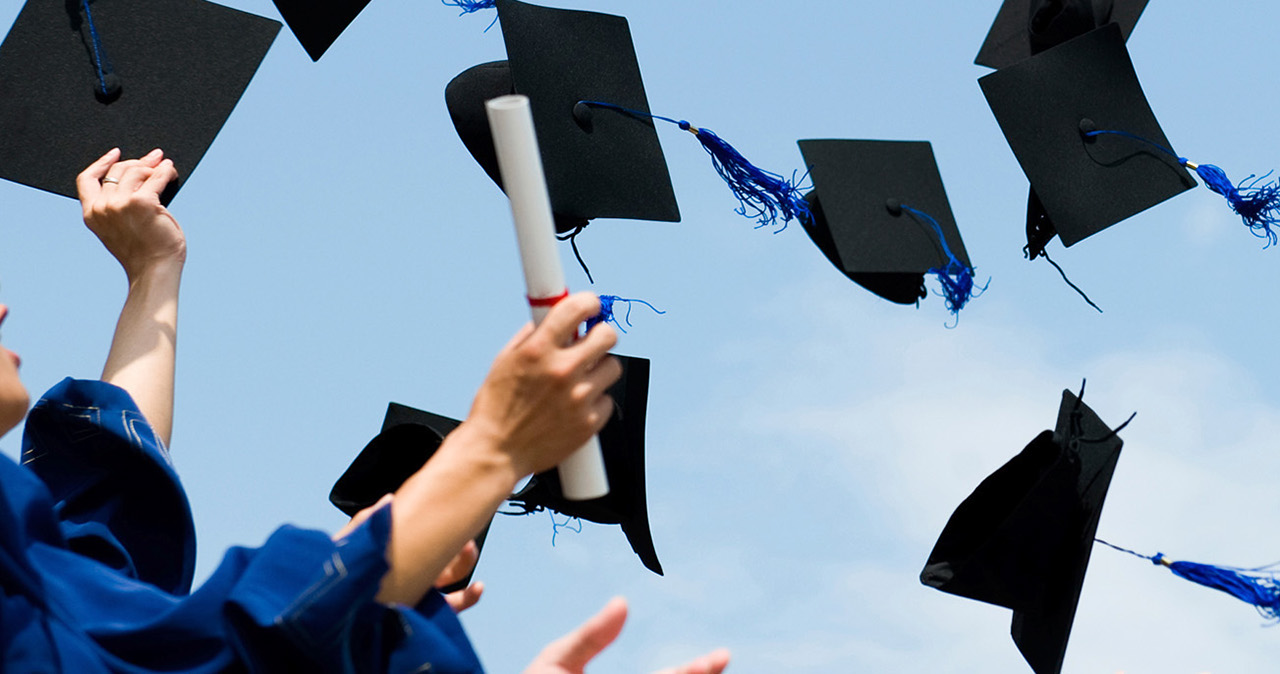 students through graduation caps in the air