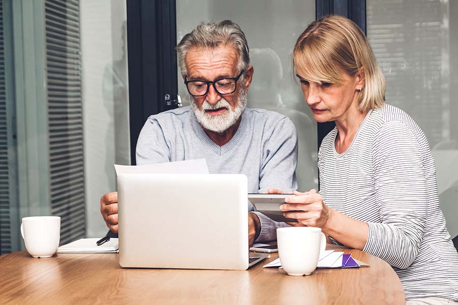 elderly couple looking at laptop concerned