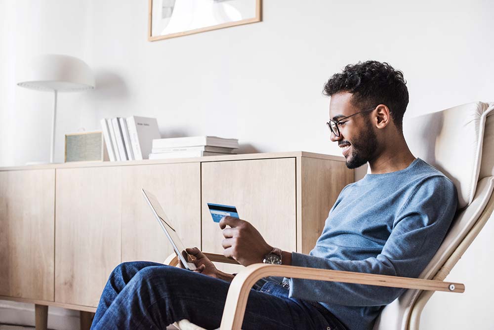 man making purchase on tablet with a credit card