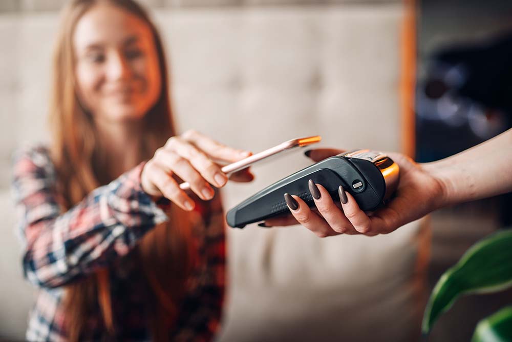 young woman using digital wallet to make purchase