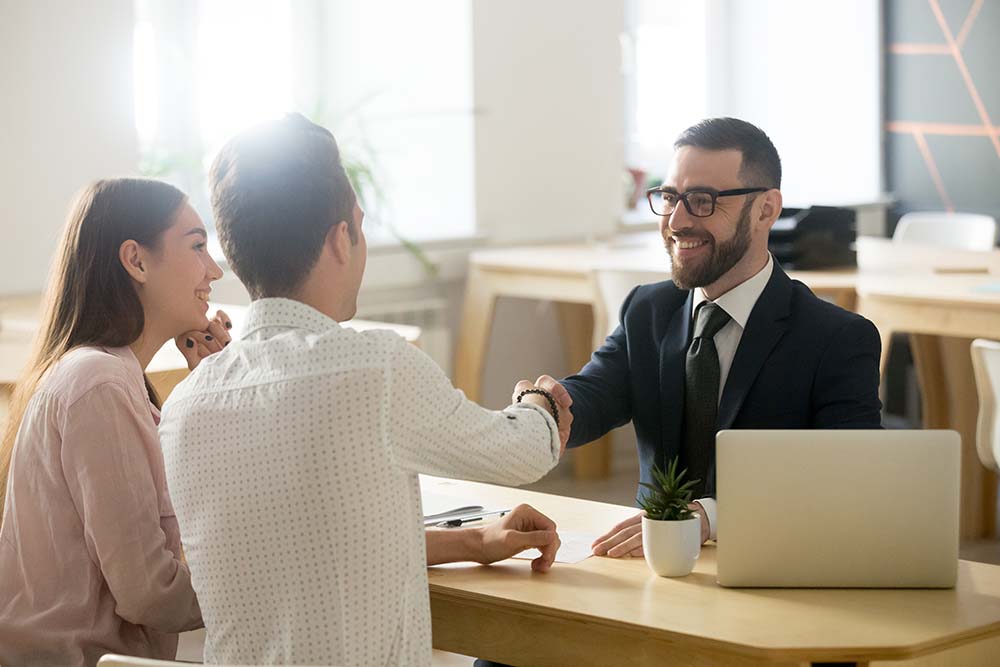 couple shaking hands with financial advisor